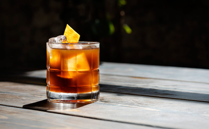 Old fashioned cocktail on a table with a lemon twist