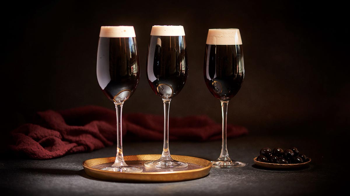 three glasses of black velvet cocktail in champagne glasses