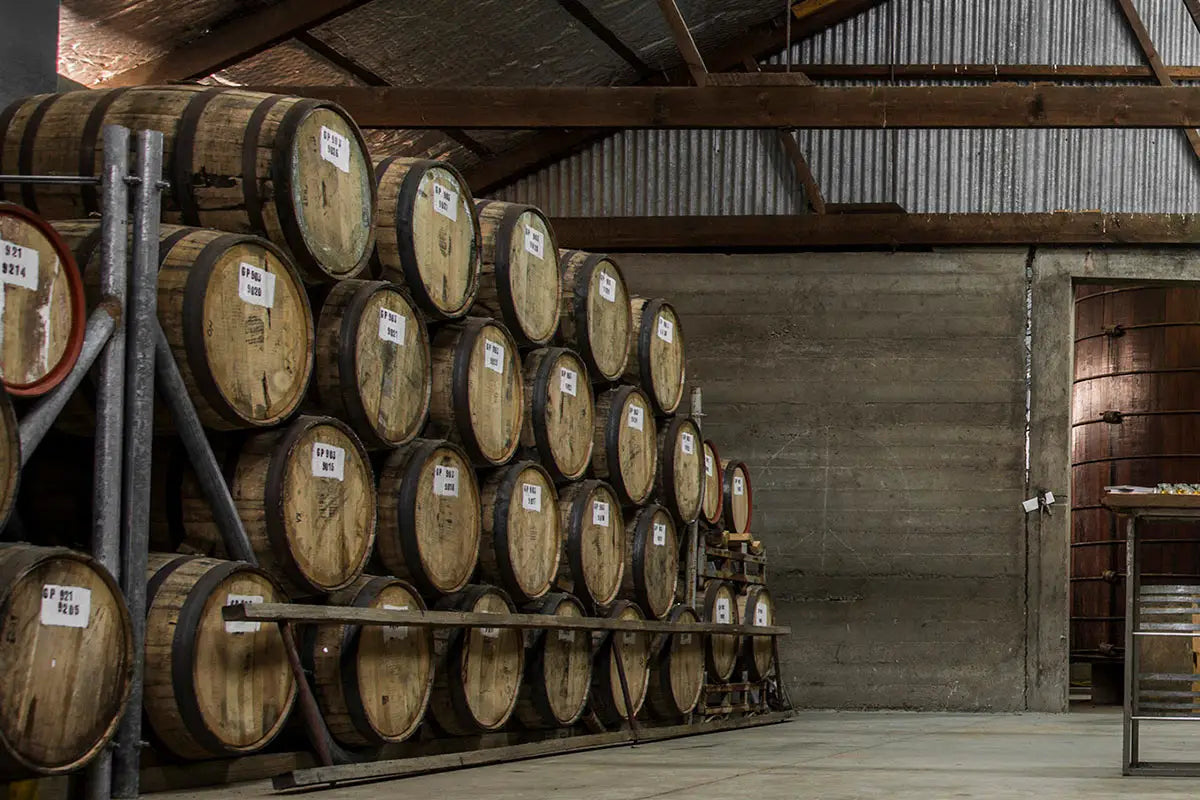 whisky barrels stacked up in a warehouse