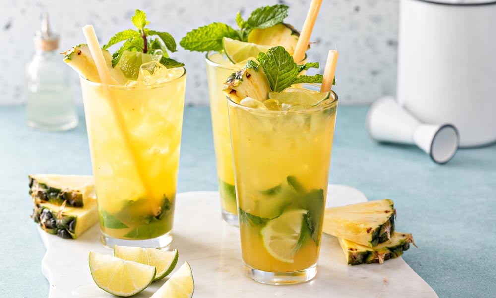 two tropical mojitos on a chopping board with pineapple slices